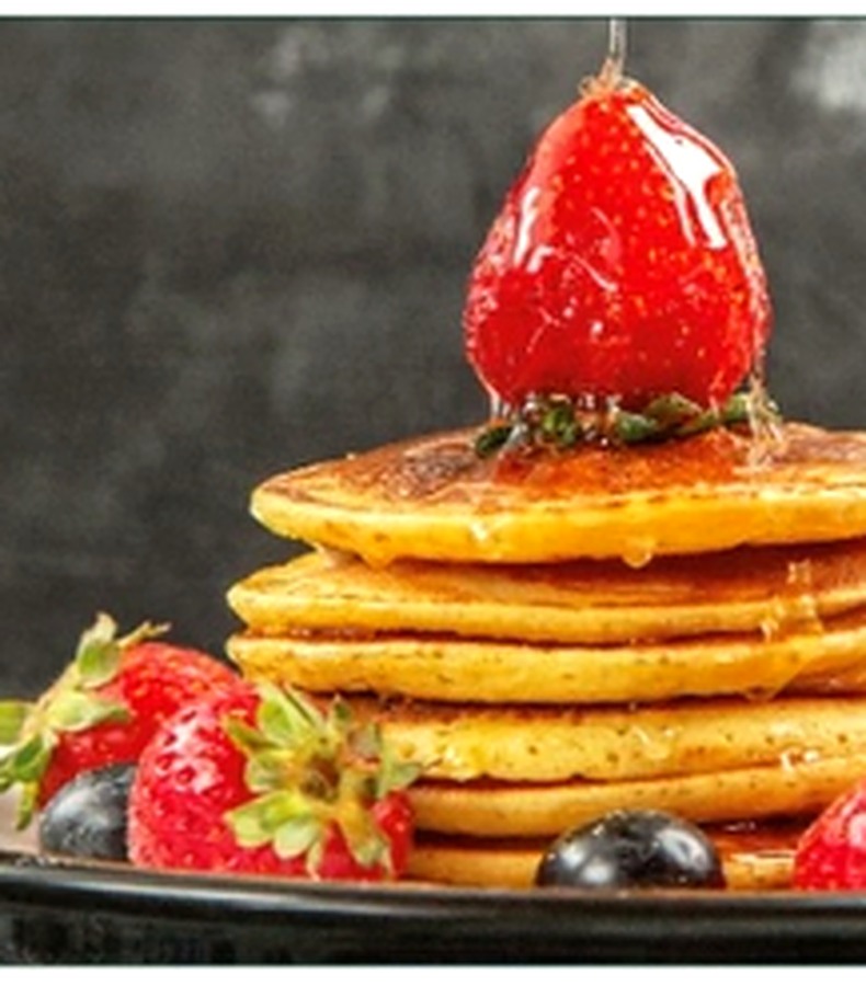 Pile de pancakes, fraises et sirop