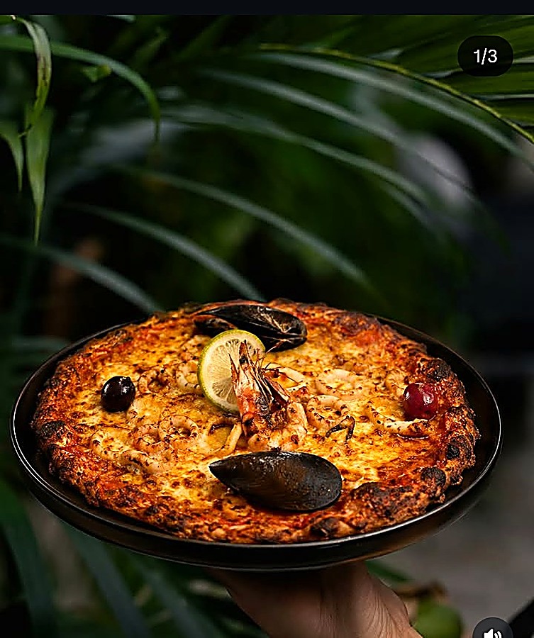 Pizza aux fruits de mer présentée en salle